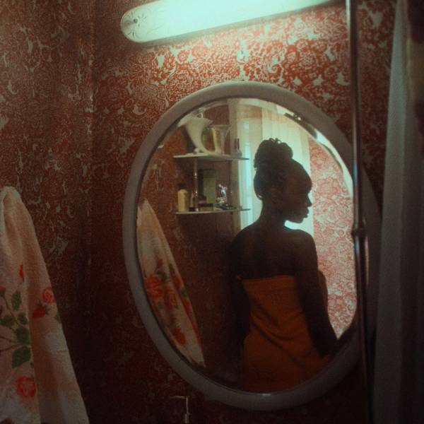 Die Schauspielerin Anna Diop steht in einer Szene des Films „Nanny“ vor dem Badezimmerspiegel.