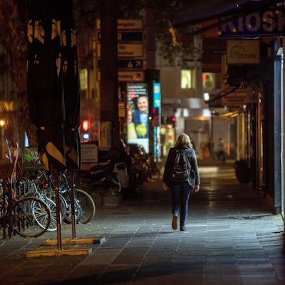 Es ist dunkel. Eine Person ist alleine unterwegs auf dem Hohenstauffenring in Köln.