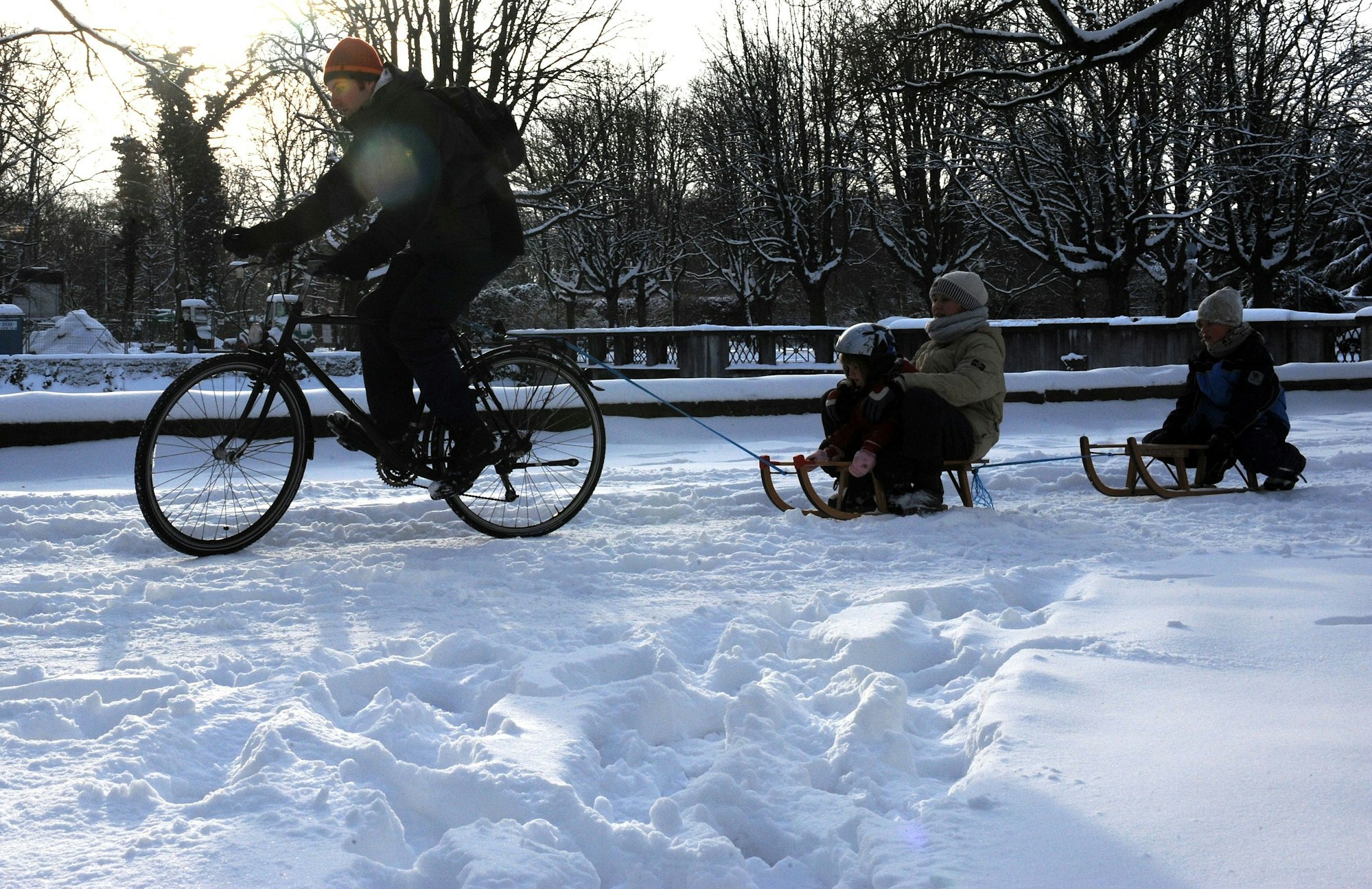 Eine Familie fährt am ersten Weihnachtstag 2010 mit Fahrrad und Schlitten durch Köln.