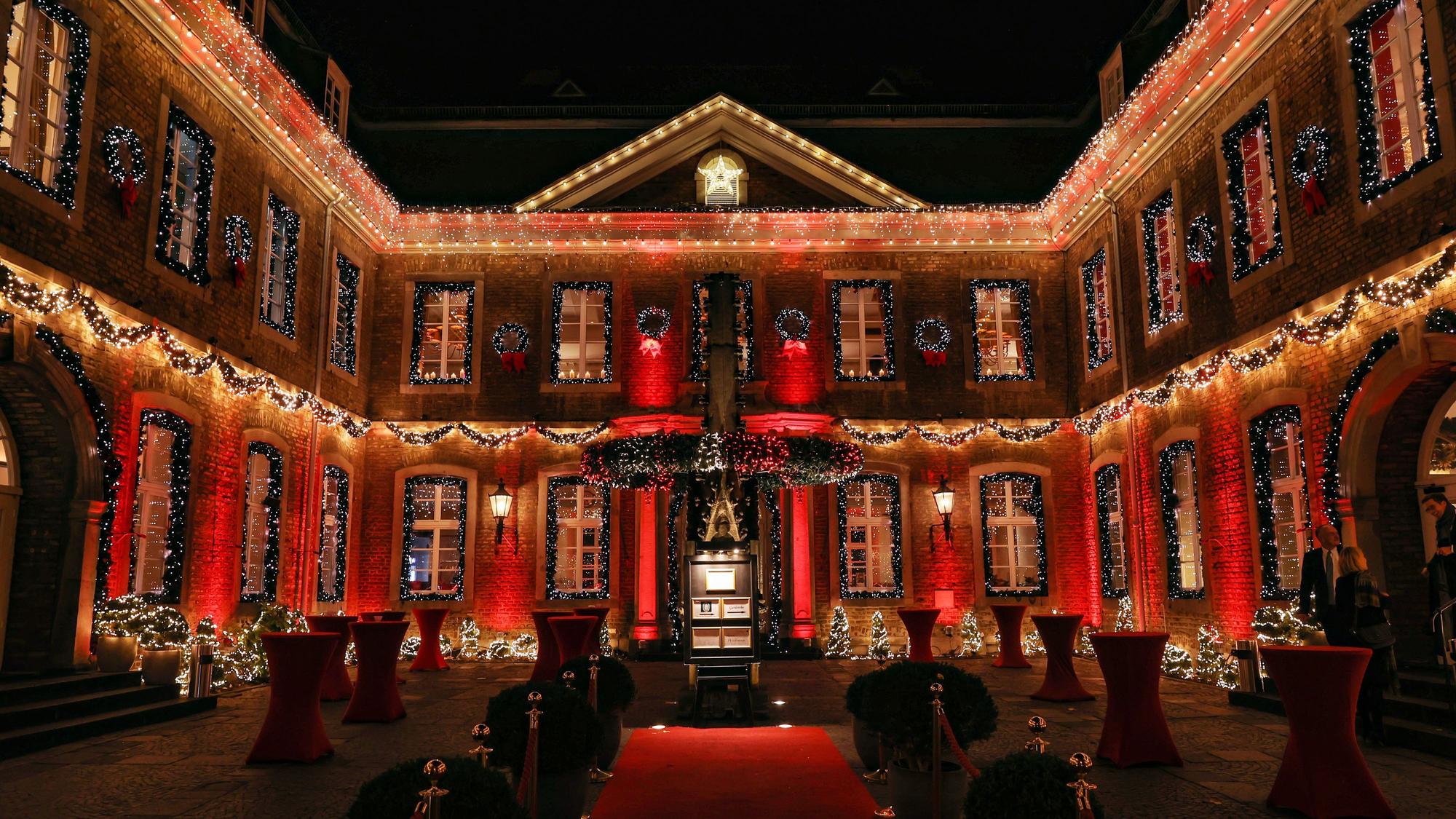 Der Innenhof der Wolkenburg ist mit zahlreichen Lichterketten sowie roten Scheinwerfern beleuchtet. An allen Fenstern hängen Girlanden.