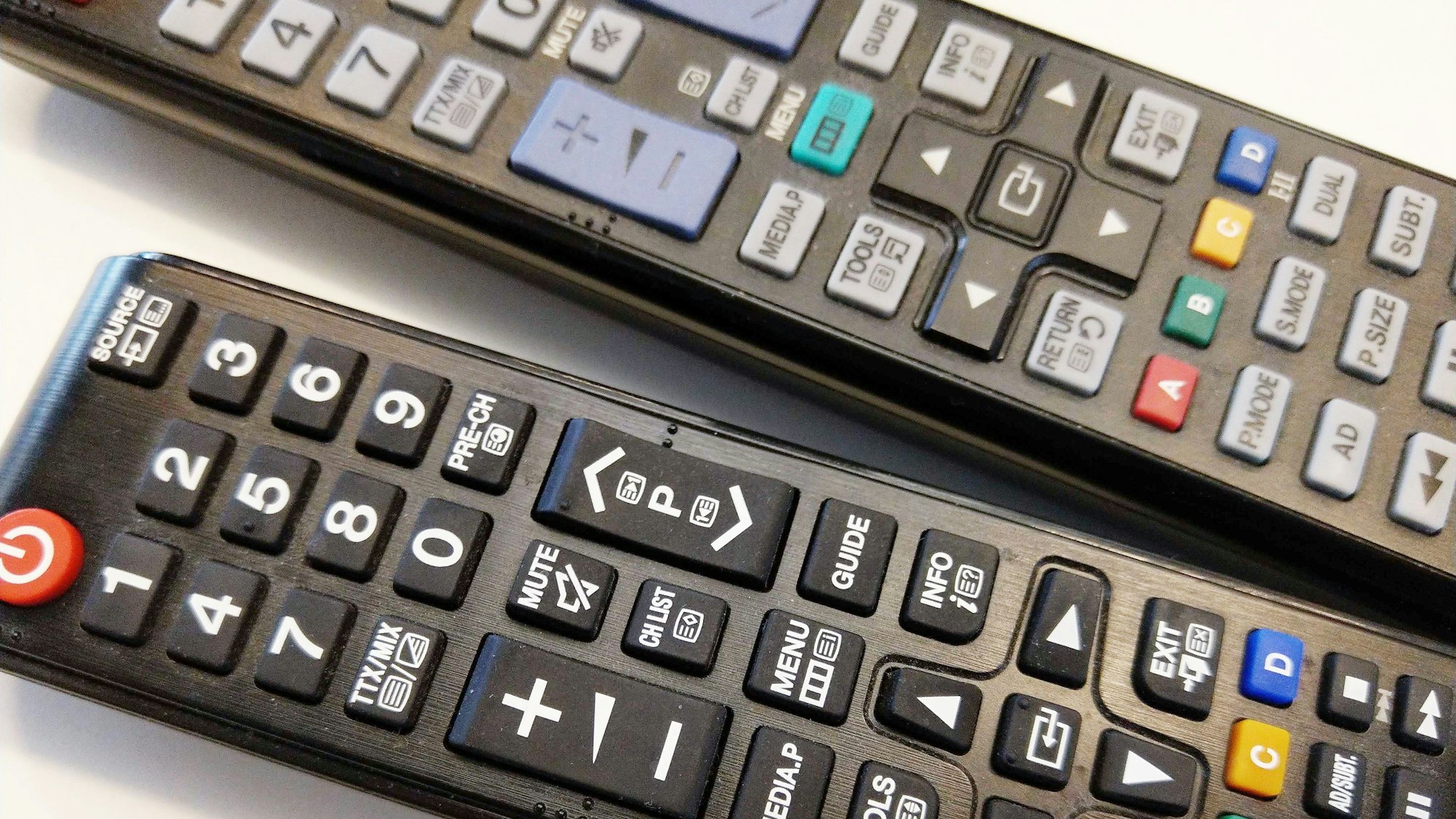 Zwei Fernbedienungen von Samsung liegen auf einem Tisch.