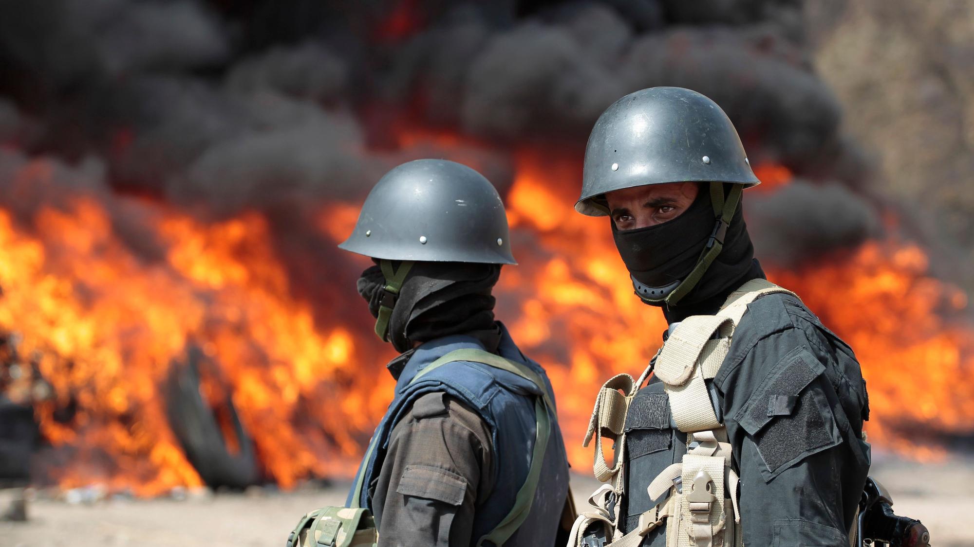 Soldaten stehen Wache, während im Hintergrund Flammen lodern (Symbolbild)picture alliance/dpa