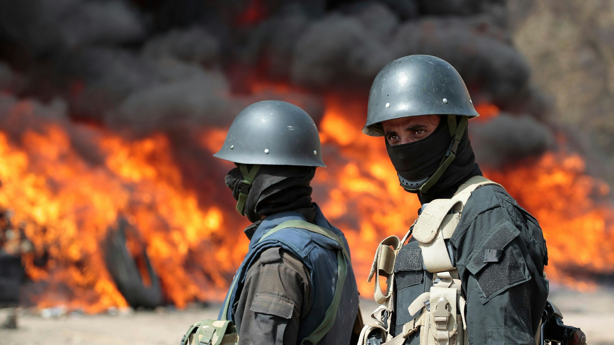 Soldaten stehen Wache, während im Hintergrund Flammen lodern (Symbolbild)picture alliance/dpa