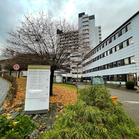 Vor dem Marienkrankenhaus in Bergisch Gladbach stehen ein Schild und ein Baum.