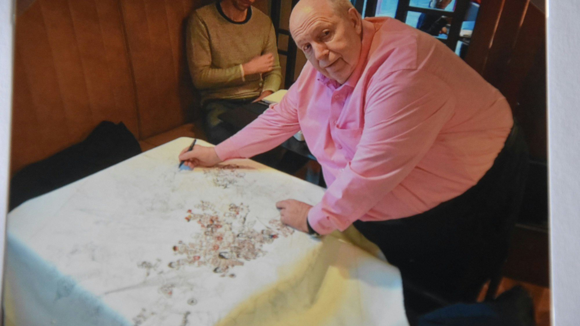 Rainer Calmund unterschreibt auf dem Bild.