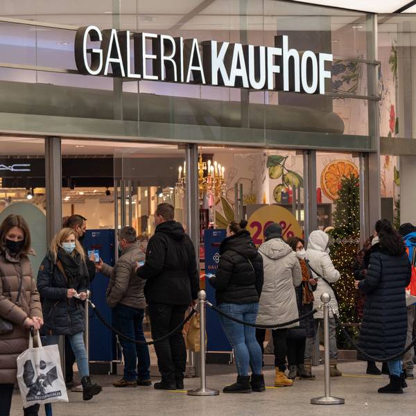 Menschen stehen in einer Schlange vor dem Eingang von Galeria Kaufhof in Köln.
