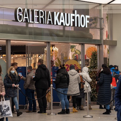Menschen stehen in einer Schlange vor dem Eingang von Galeria Kaufhof in Köln.