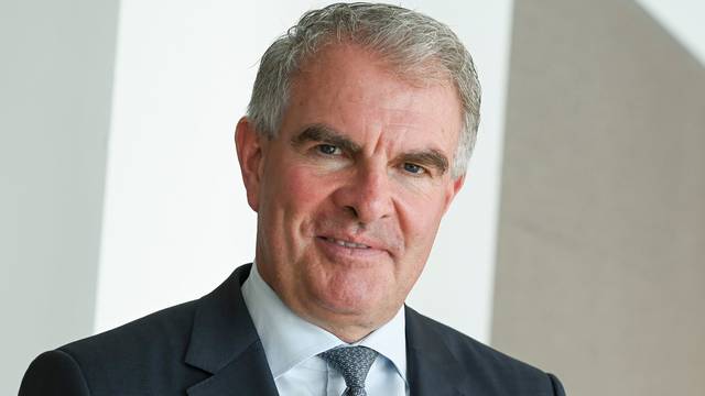 Lufthansa-Chef Carsten Spohr trägt einen Anzug und guckt in die Kamera.
