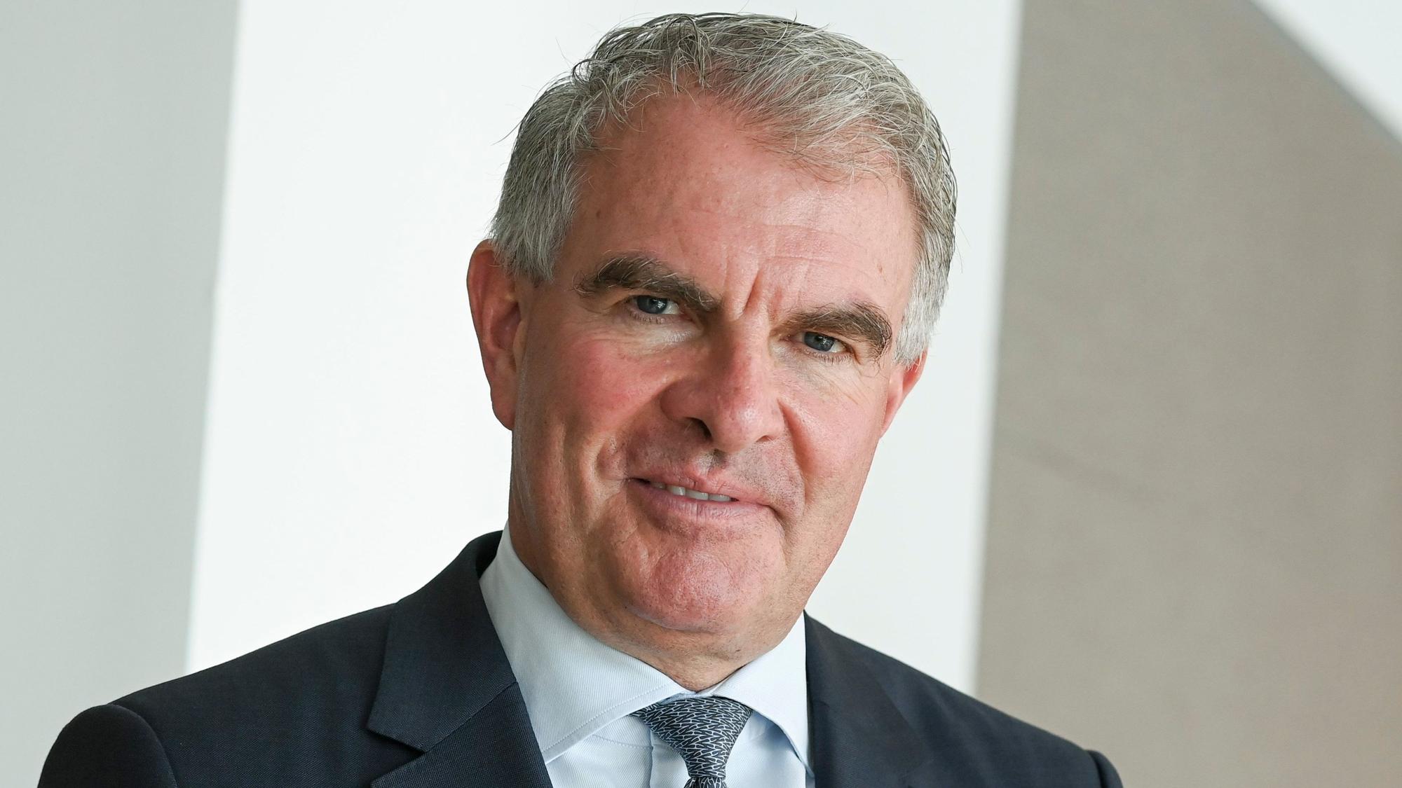 Lufthansa-Chef Carsten Spohr trägt einen Anzug und guckt in die Kamera.
