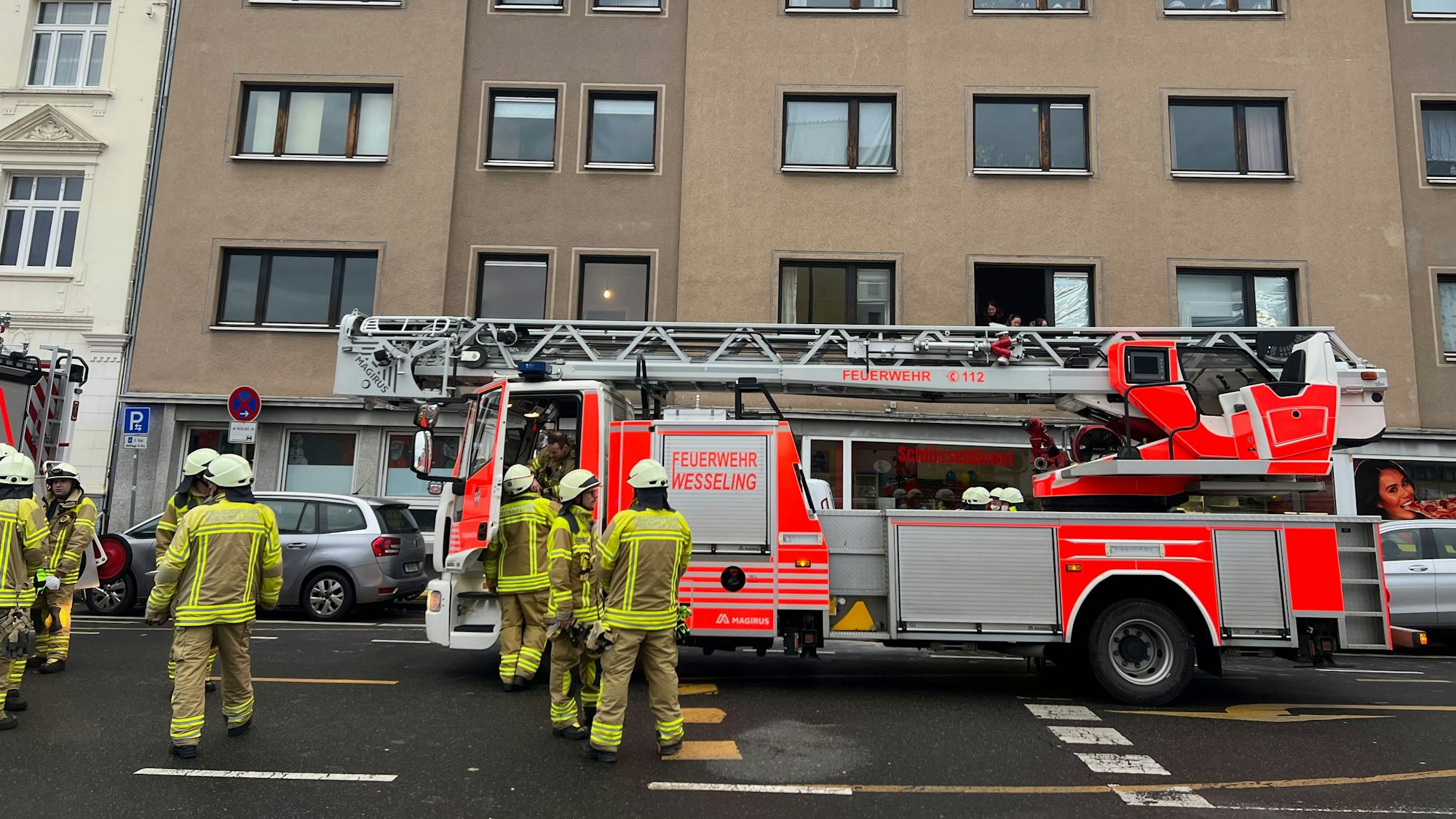 Feuerwehrleute und ein Feuerwehrauto stehen vor dem Haus, in dem es gebrannt hat.