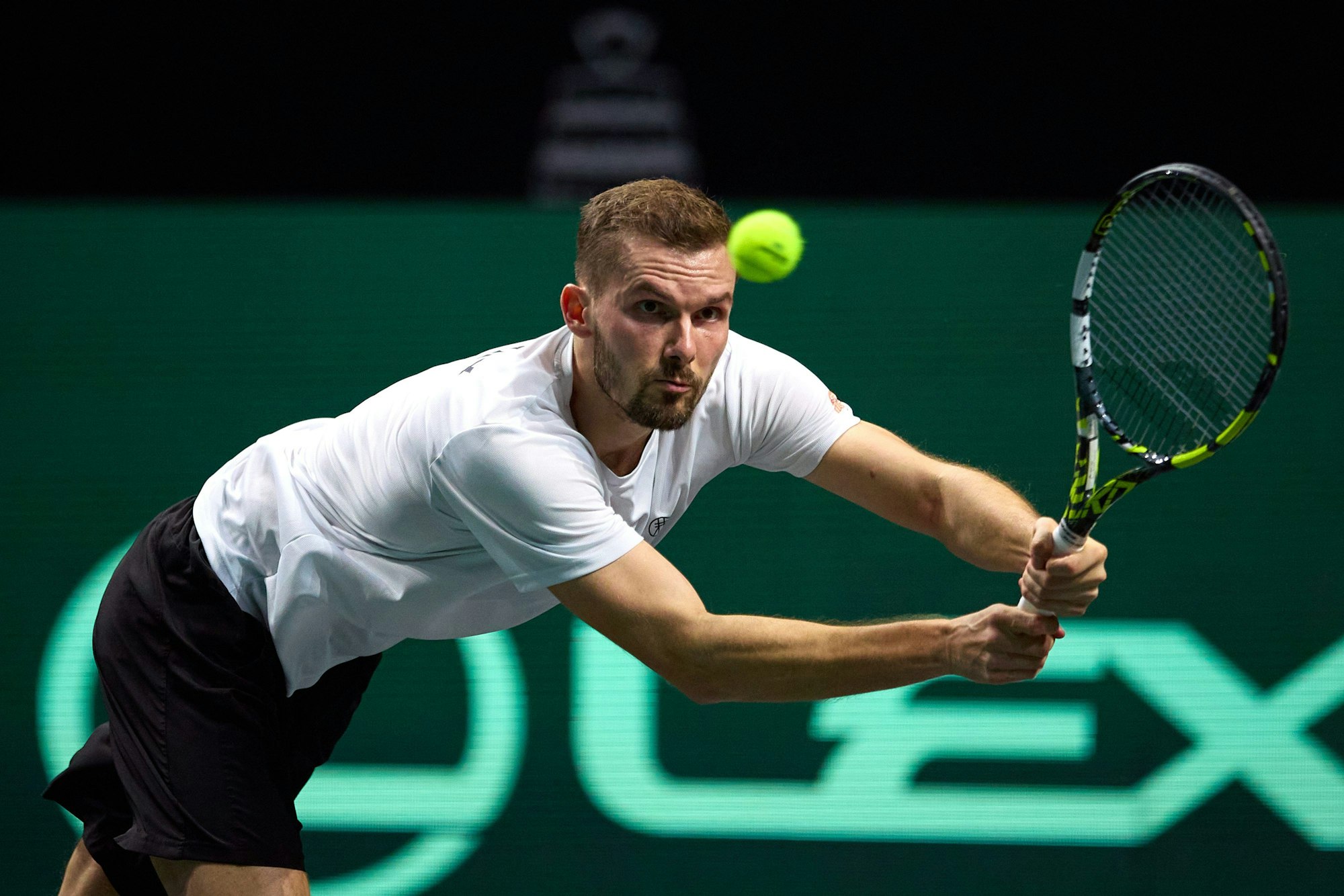 Oscar Otte hechtet mit ausgetreckten Armen und Tennisschläger in beiden Händen einem Ball hinterher.