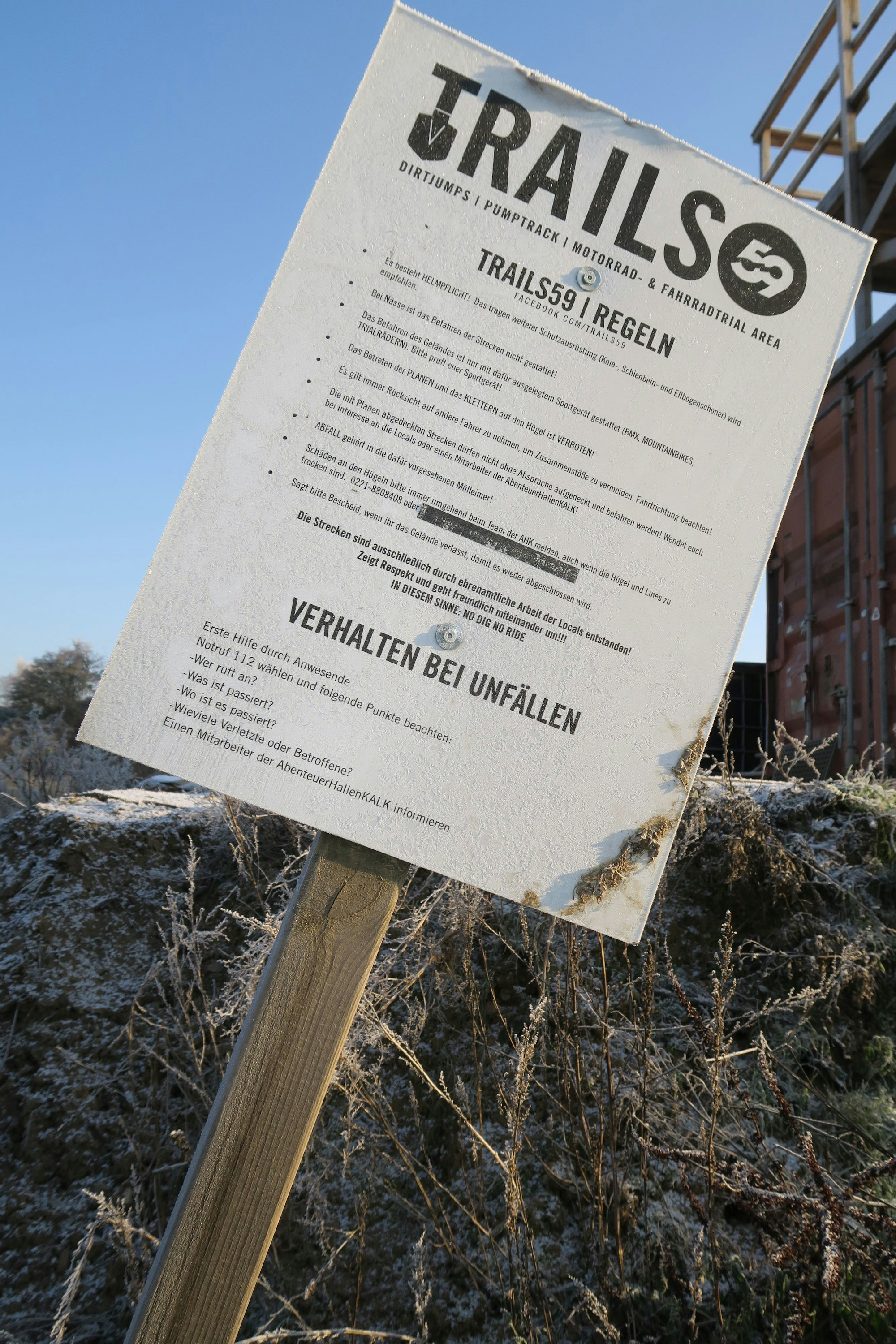 Schild mit der Aufschrift: Trails 59, Regeln und Verhalten bei Unfällen