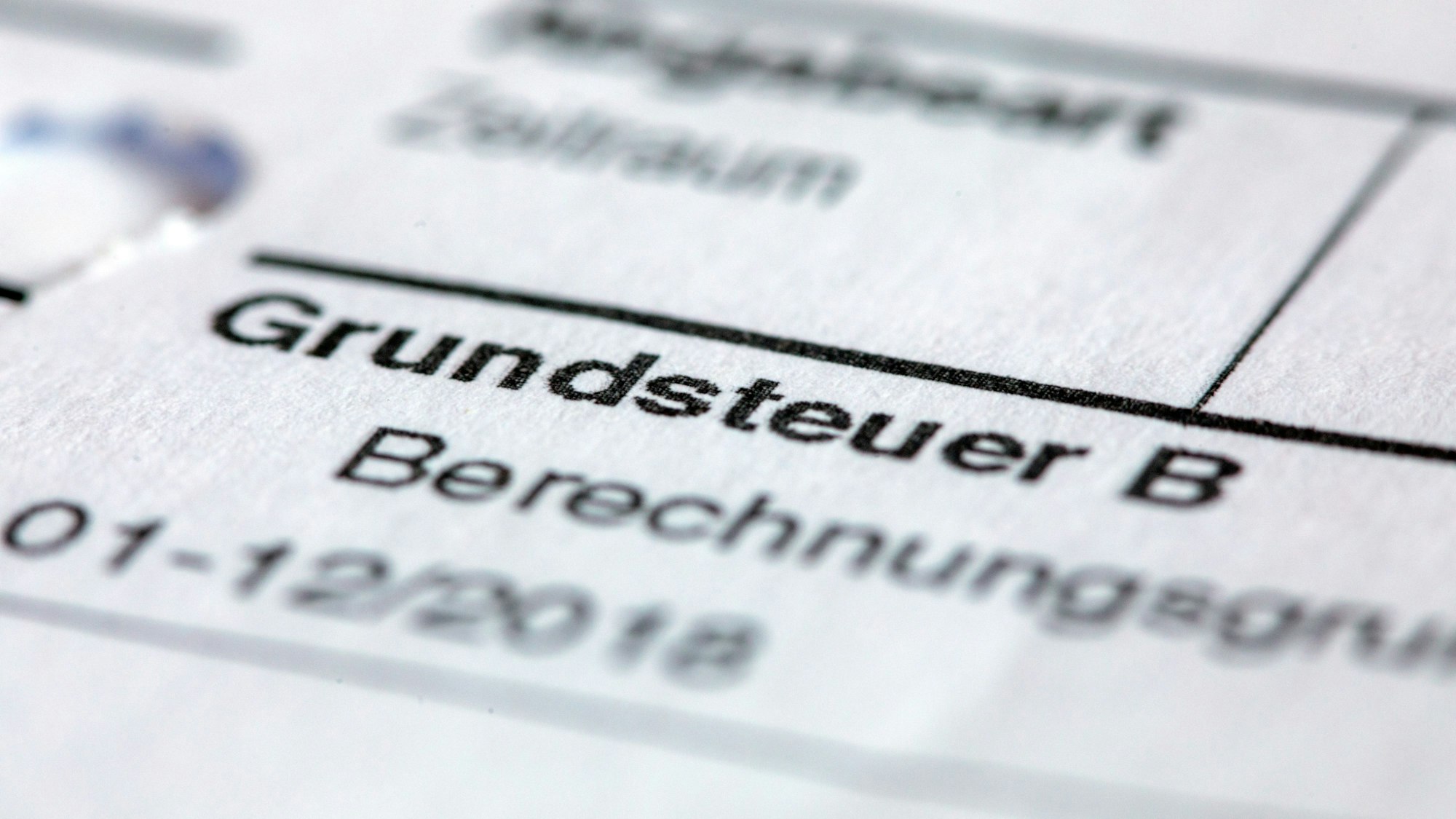 Ein Abgabenbescheid für die Entrichtung der Grundsteuer liegt auf einem Schreibtisch.