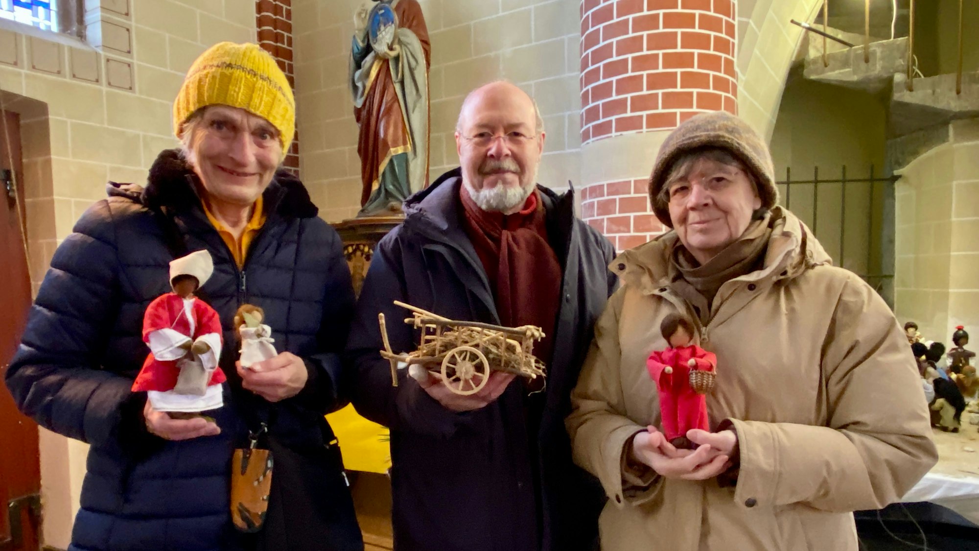 Gabriele Roeckerath, Jürgen und Elisabeth Vosen, hier im Dezember 2022, gestalteten die Figuren für die Weihnachtskrippe in der St. Sebastianuskirche in Frechen-Königsdorf.