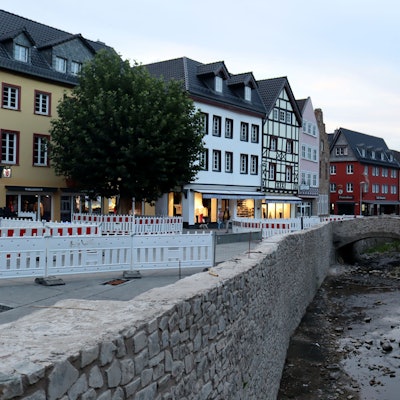 Die Stadt Bad Münstereifel bei einer Aufnahme in den Abendstunden im August 2022. Die Erft ist noch voller Steine, die Mauern noch nicht komplett wiederhergestellt, der Markt ist abgesperrt wegen Wiederaufbauarbeiten.