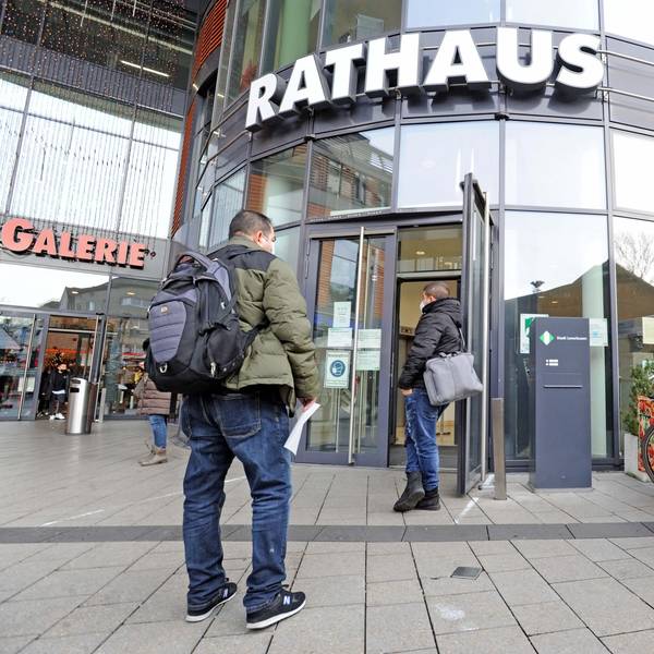 Am Eingang des Leverkusener Rathaus warten Bürger.