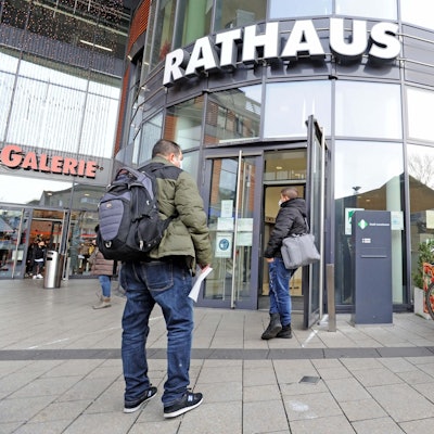 Am Eingang des Leverkusener Rathaus warten Bürger.