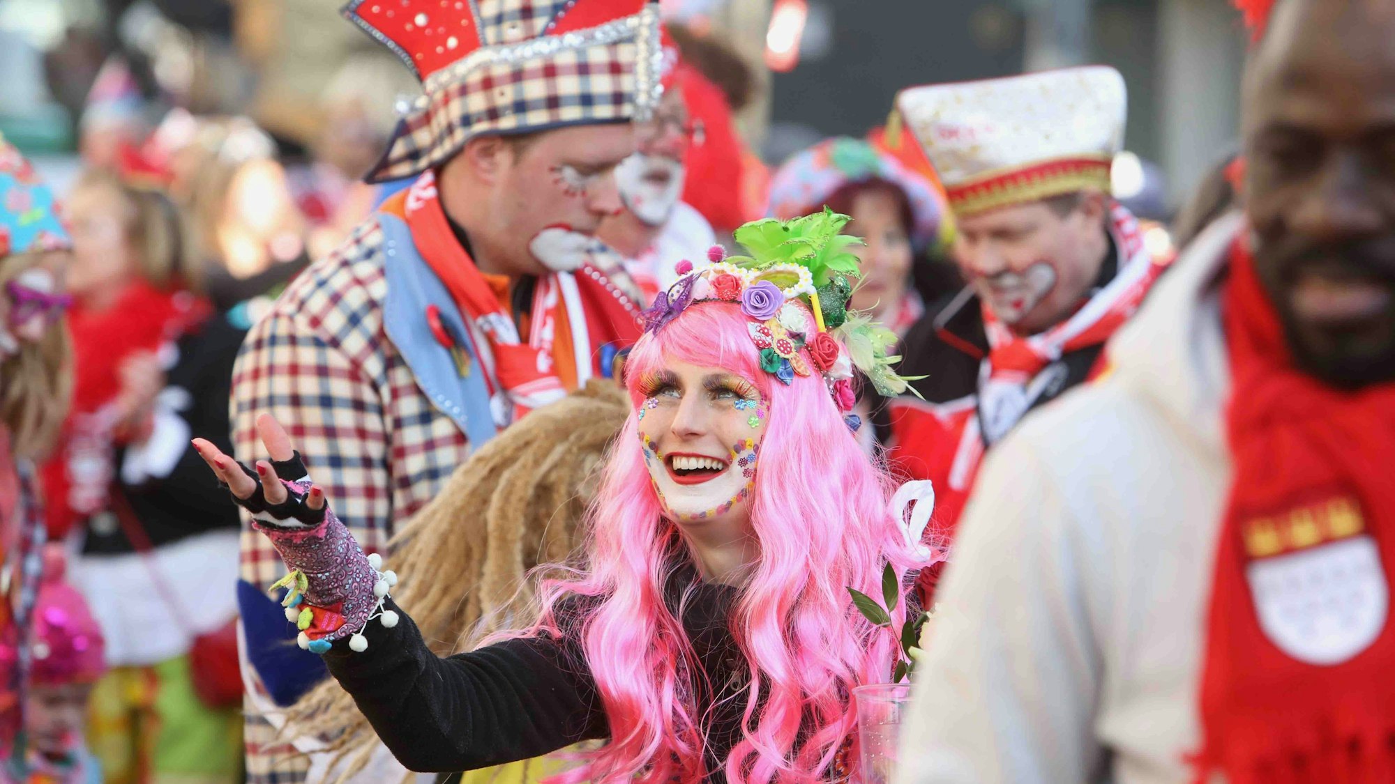 Die „Ultras GKKG“ in Karnevalskostümen, in der Mitte eine Frau mit pinker Perücke.
