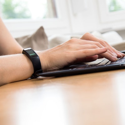 Eine Person tippt etwas in einen Laptop ein.