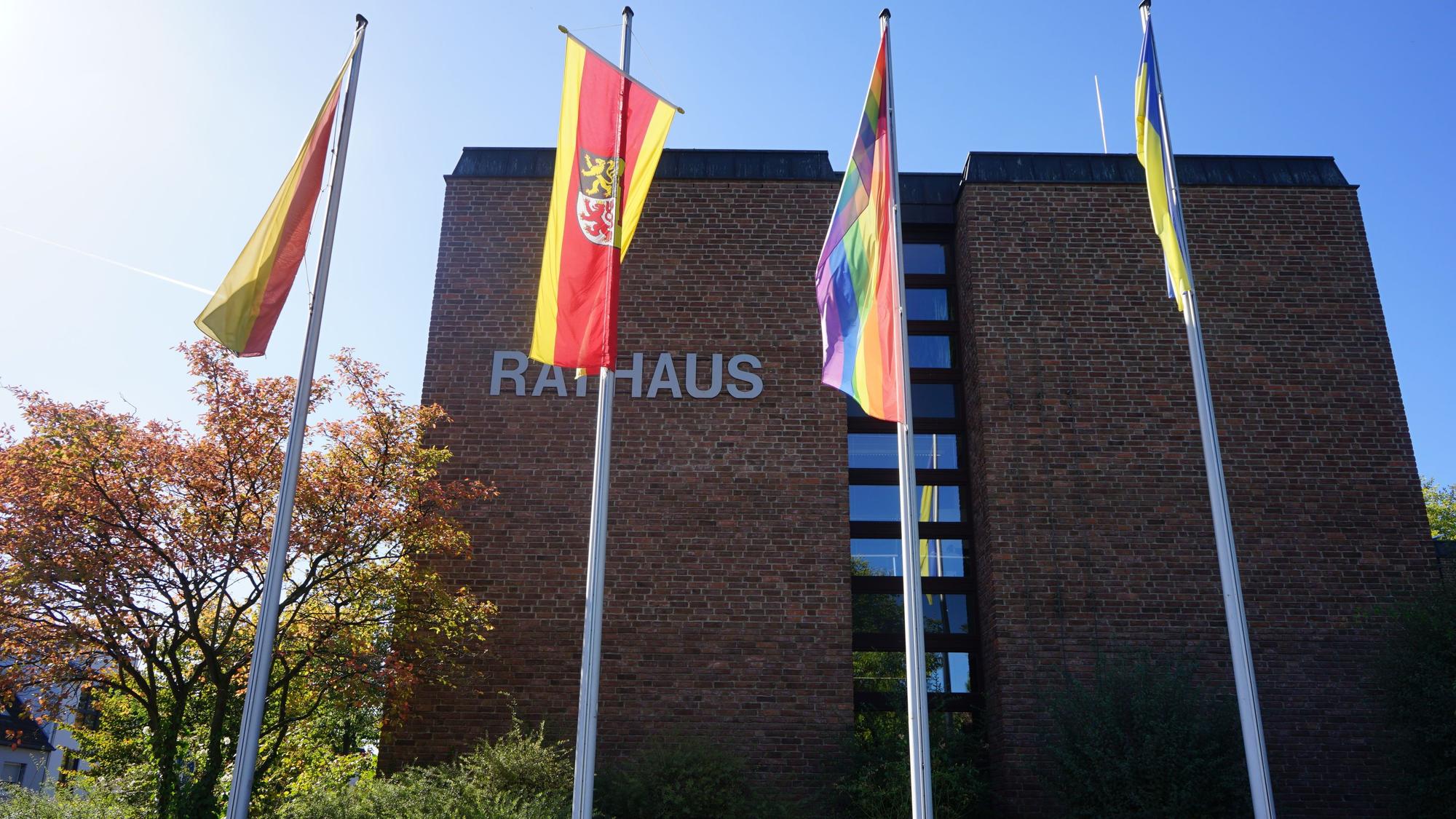 Das Foto zeigt das Kerpener Rathaus. Davor wehen mehrere Fahnen.
