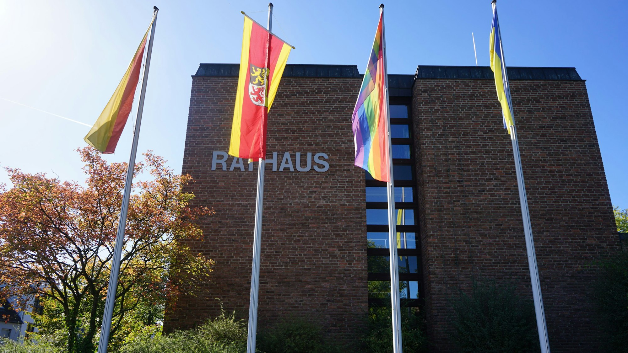 Das Foto zeigt das Kerpener Rathaus. Davor wehen mehrere Fahnen.