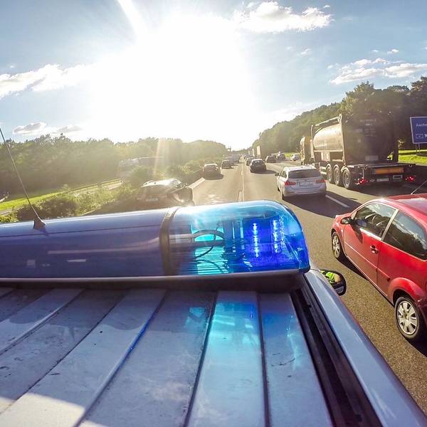 Ein Streifenwagen und andere Autos fahren auf der Autobahn.