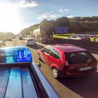 Ein Einsatzwagen fährt auf einer Autobahn vorbei an anderen Autos.