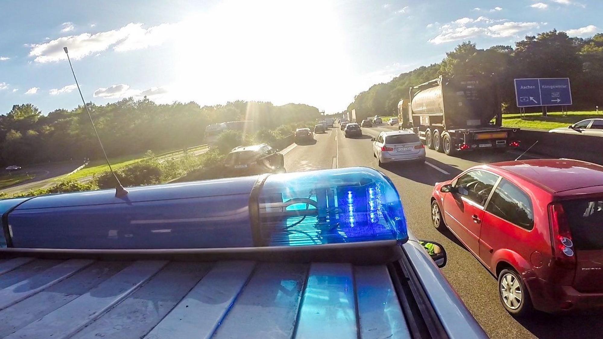 Ein Streifenwagen (VW Multivan) der Autobahnpolizei Koeln fährt am Montag mit Blaulicht und Martinshorn auf der Autobahn A4 in FR Aachen kurz vor der AS Koeln-Poll durch eine Rettungsgasse in einem Verkehrsstau.