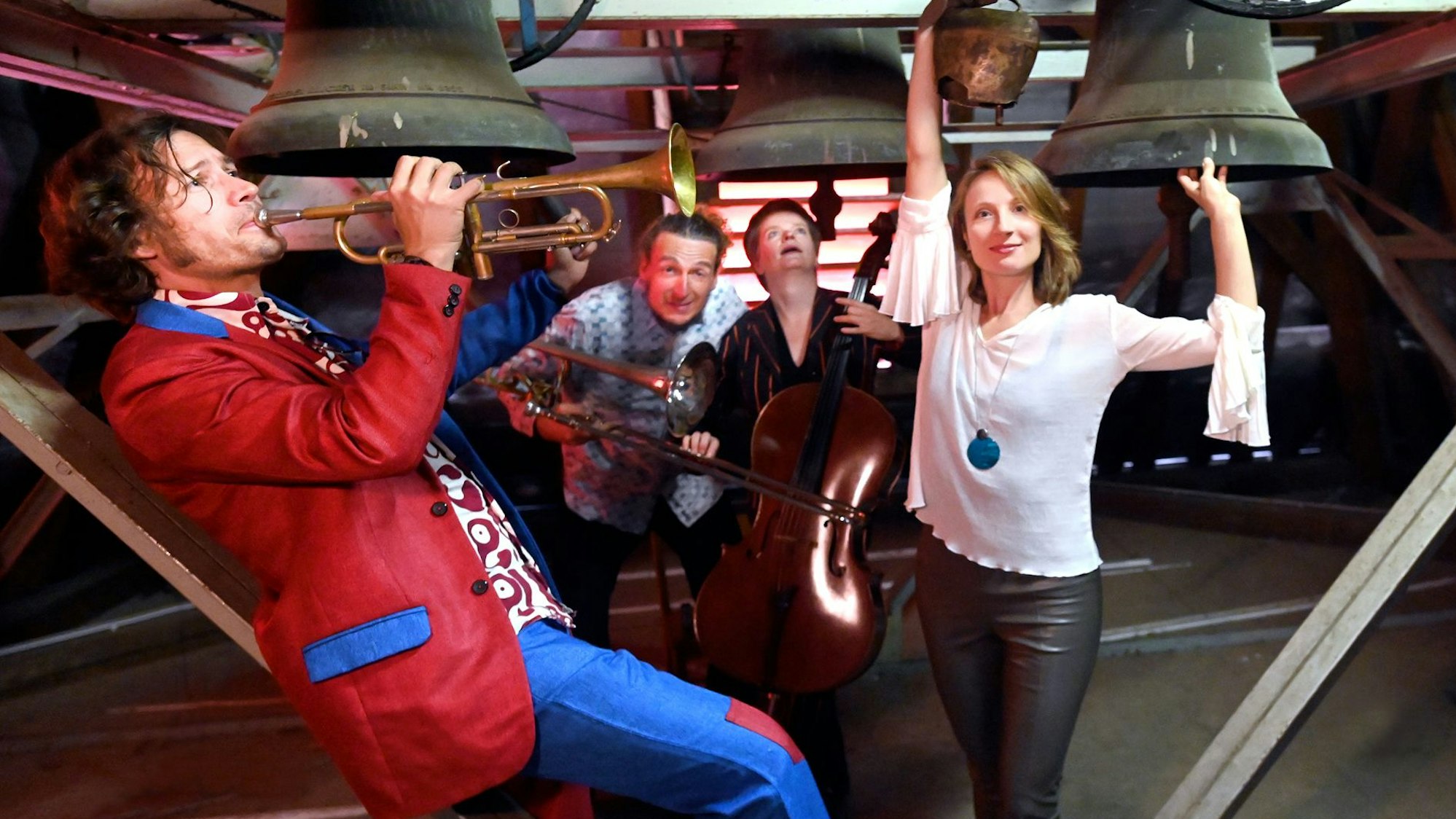Matthias Schriefl und sein Quartett musizieren in einem Glockenturm. Schierfl trägt eine auffallend rotes Jackett mit blauem Kragen.