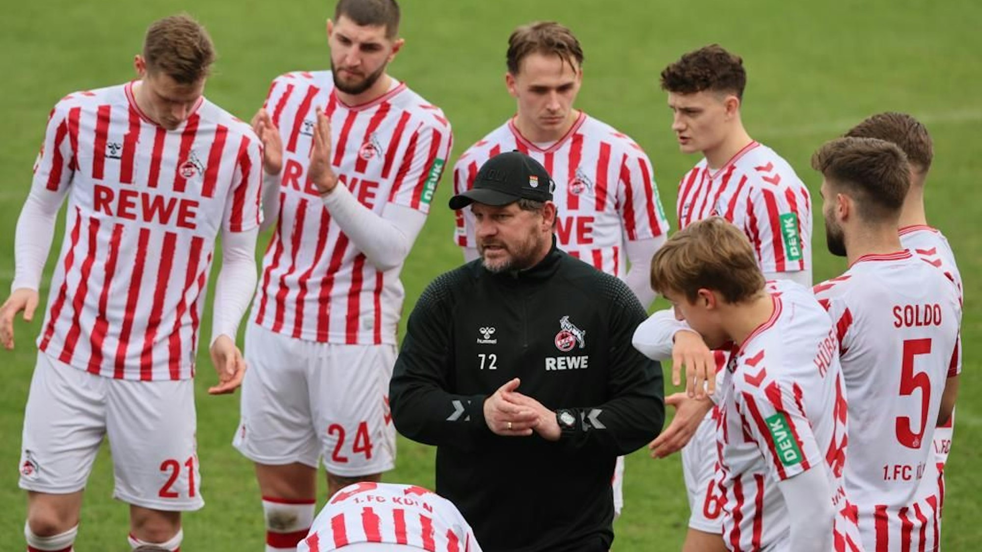 Steffen Baumgart steht umringt von seinen Spielern und spricht.