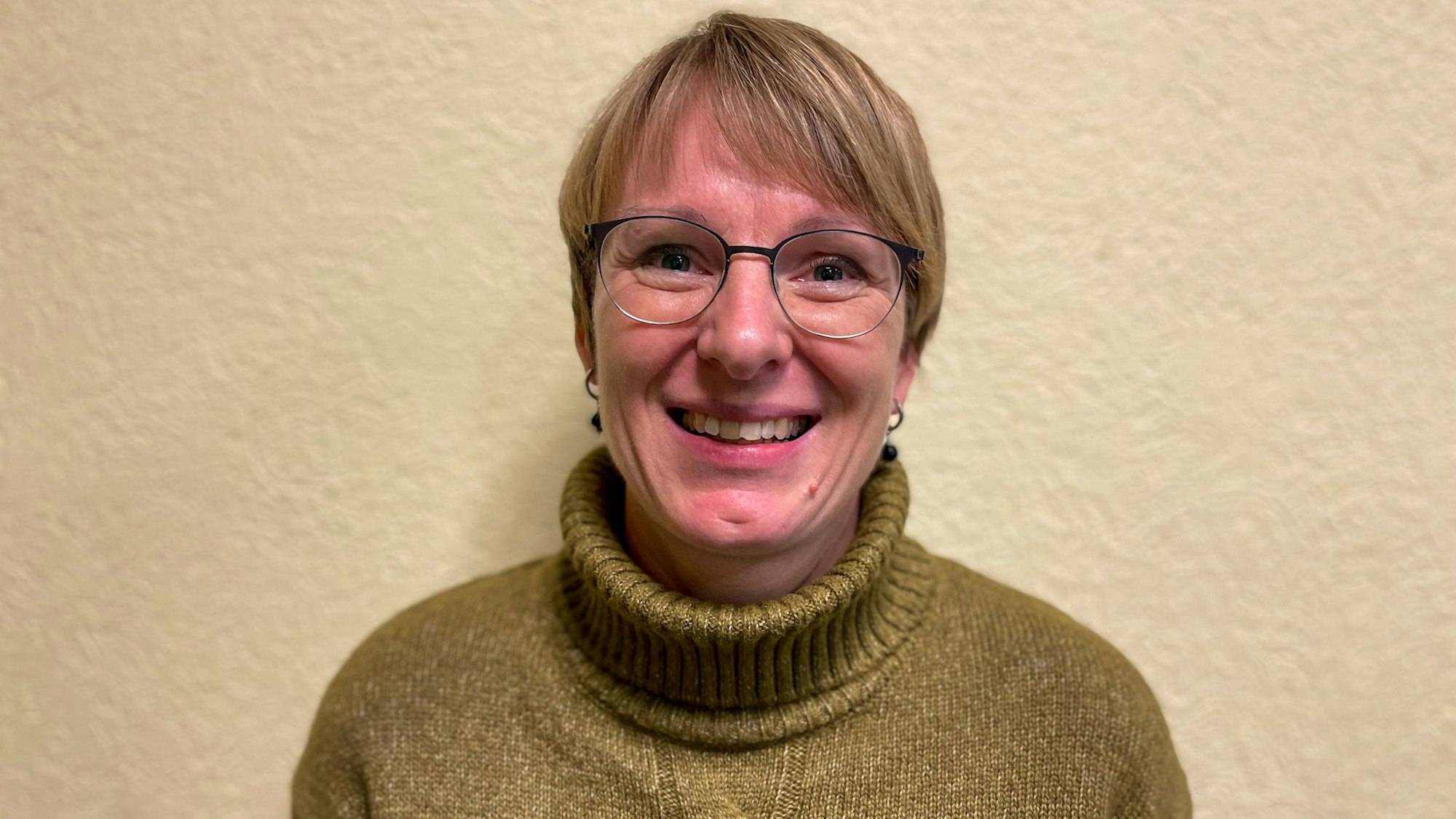 Porträtaufnahme von Susanne Heuckmann, Schulleiterin der Grundschule in Paffrath, vor einer Wand.