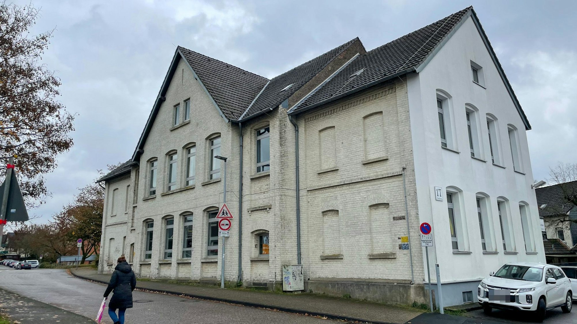 Das helle Gebäude der Grundschule Paffrath vor bewölktem Himmel.