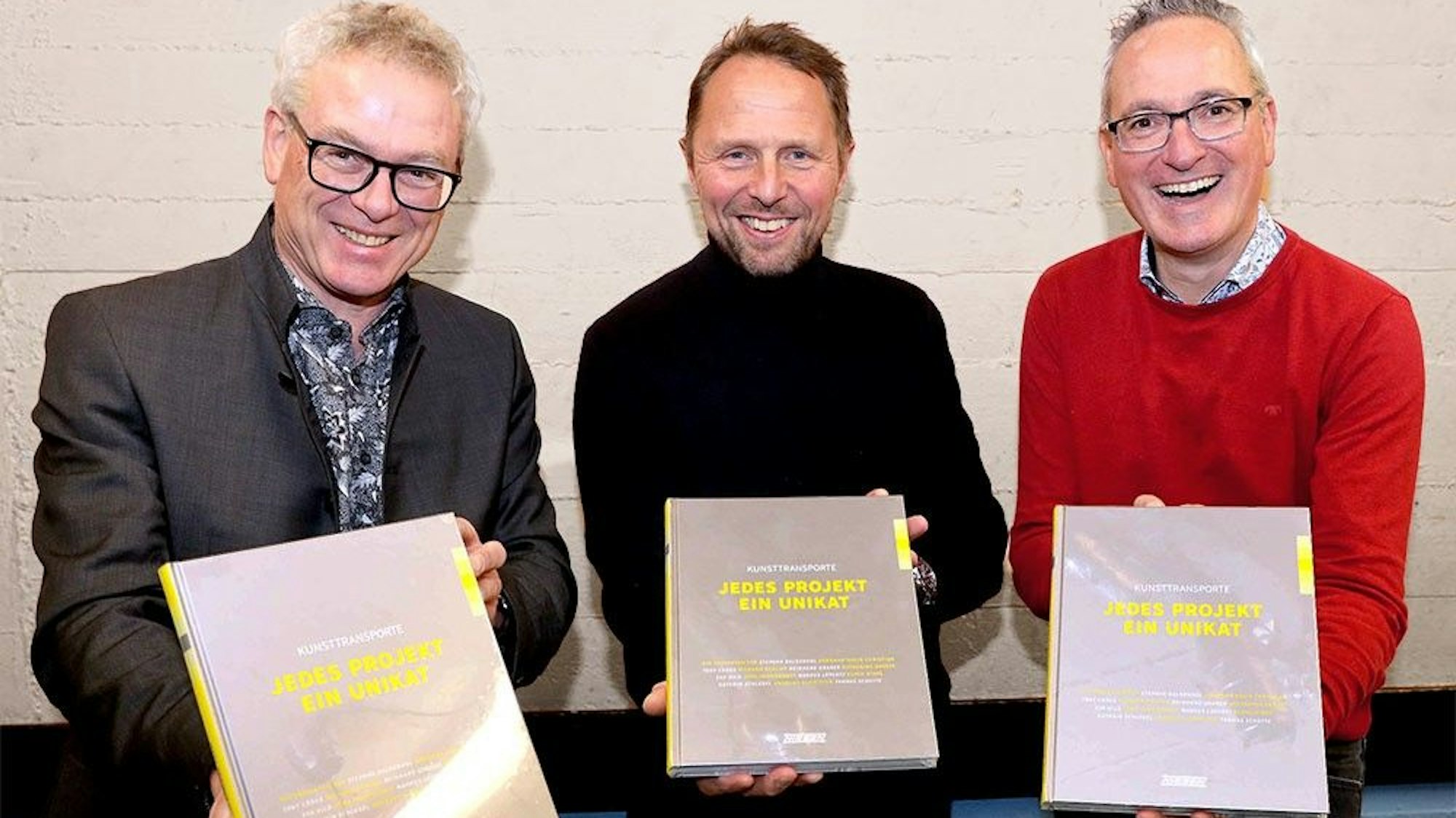 Übergabe des Bildbandes "KUNSTTRANSPORTE – JEDES PROJEKT EIN UNIKAT" an Leverkusener Oberbürgermeister Uwe Richrath (Mitte) am 13.12.2022 durch Klaus Niesen (links) und Markus Kalcker (rechts).