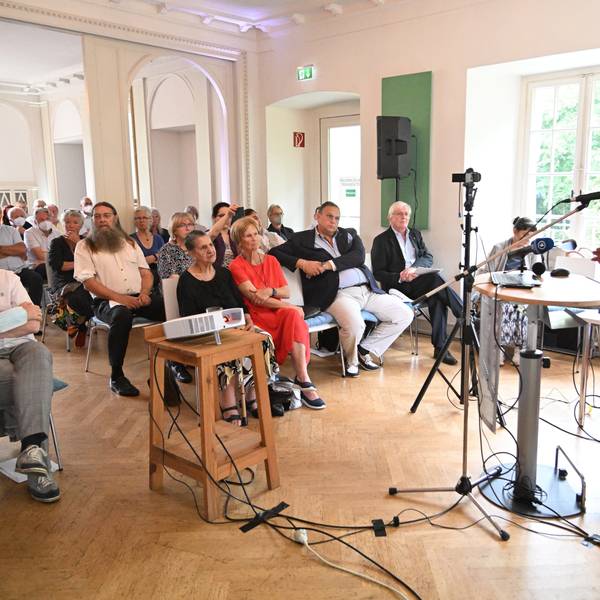 Antiziganismus-Beauftragte Mehmet Gürcan Daimagüler hält eine Rede vor sitzendem Publikum im Schloss Eulenbroich.