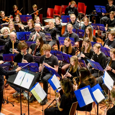 Die Musikschüler sitzen im Halbkreis und spielen ein Konzert.