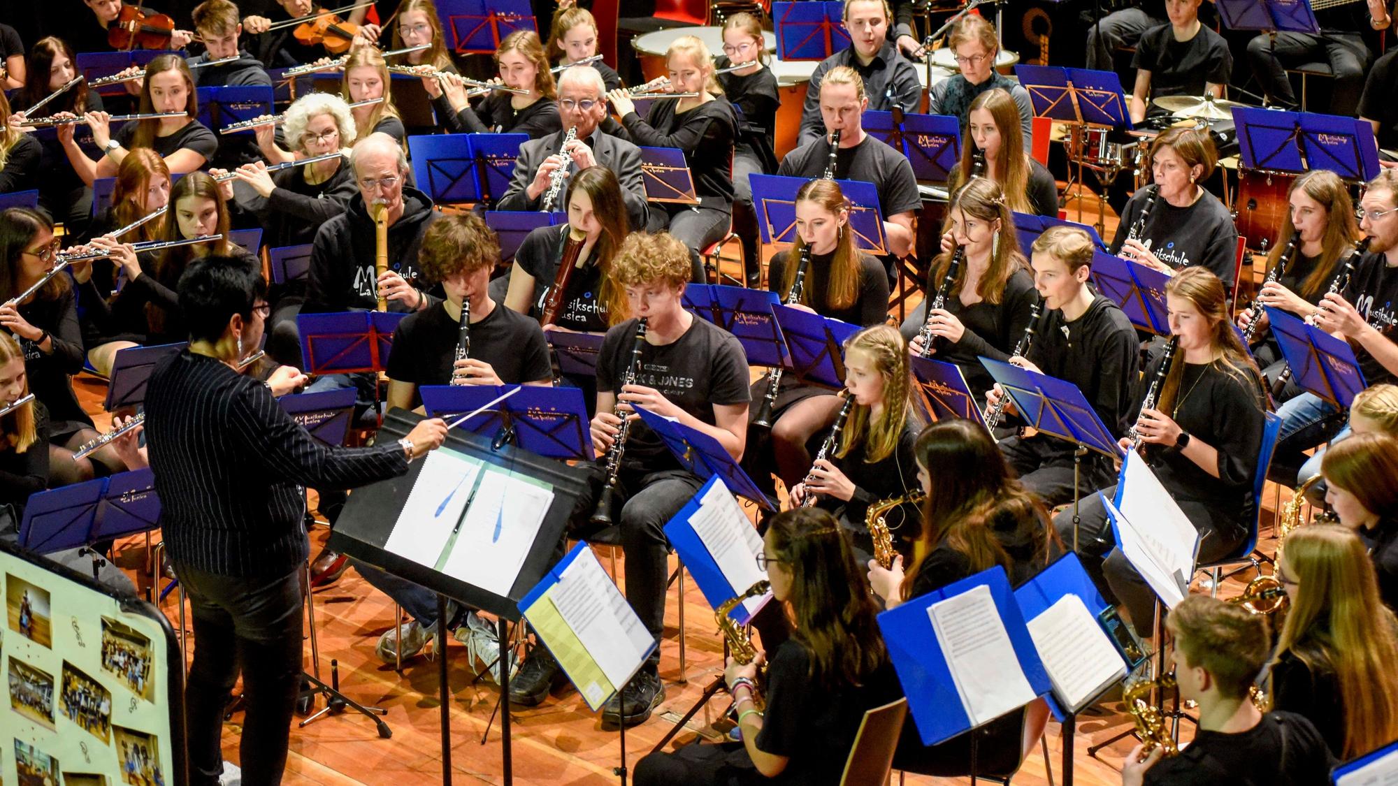 Die Musikschüler sitzen im Halbkreis und spielen ein Konzert.