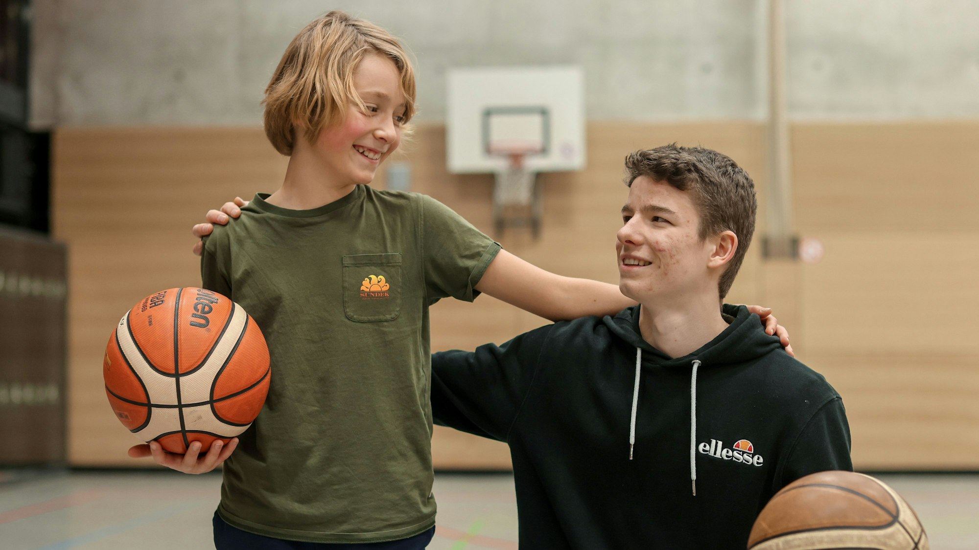 Nicolas Dohmen stellt seinen Basketballtrainer Fiete Bade in der Sporthalle des Apostelngymnasiums Köln vor.
