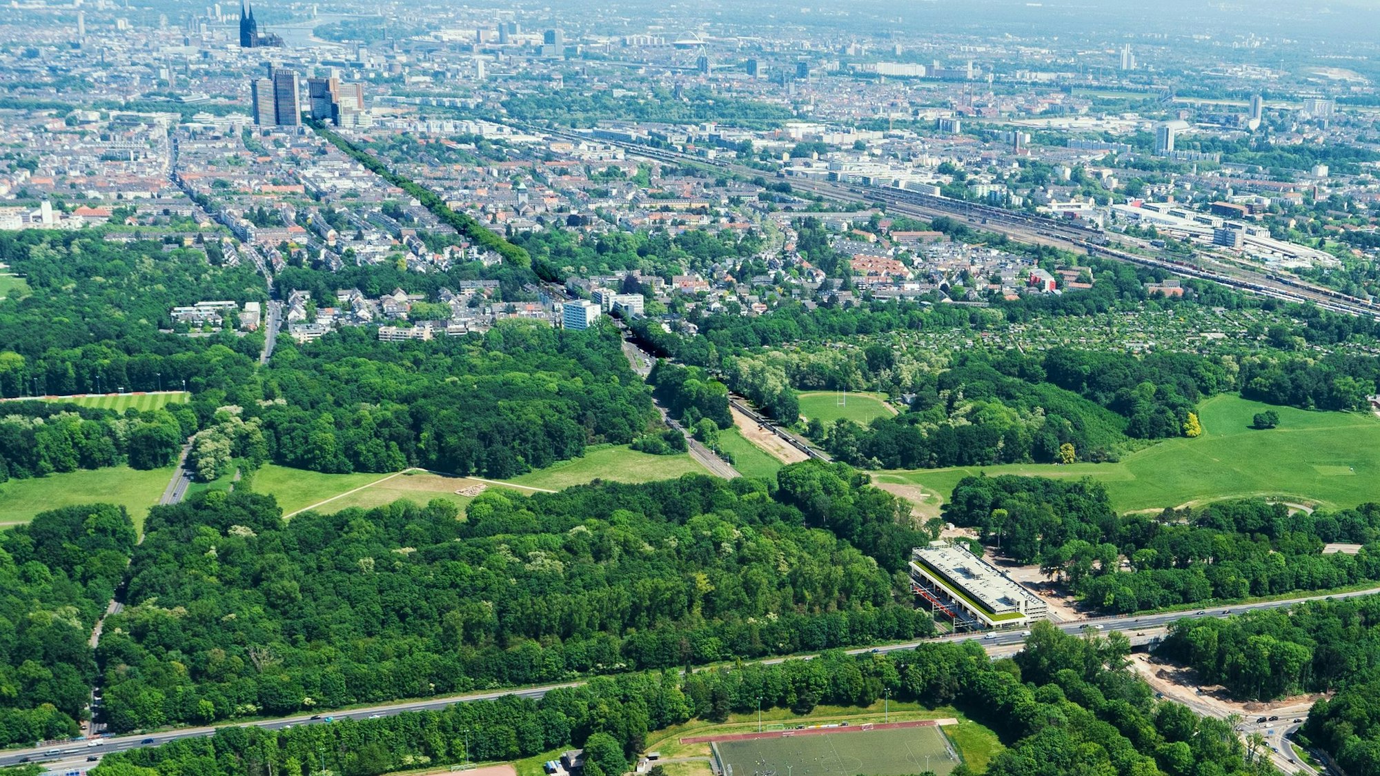 Die Visualisierung zeigt die geplante Parkpalette von oben, im Hintergrund ist Köln zu sehen.