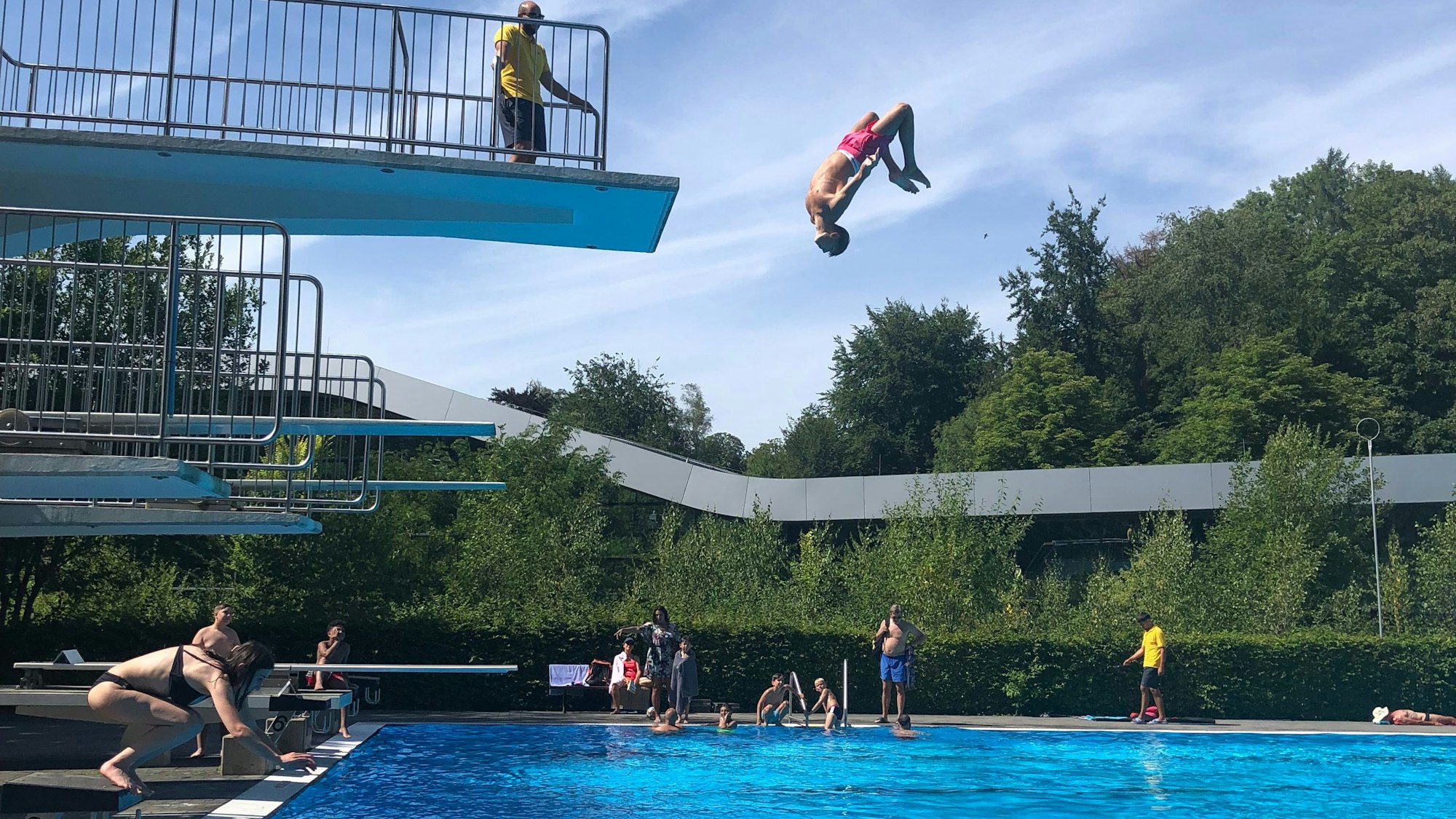 Viel los im Freibad Wiembachtal: Ein Junge springt einen Salto vom 5-Meter-Turm