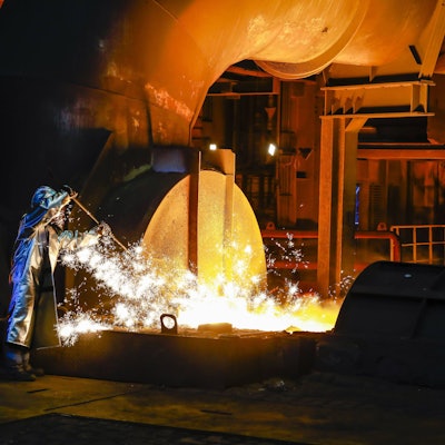 ThyssenKrupp Steel, ein Stahlarbeiter im Schutzanzug entnimmt eine 1500 Grad heisse Roheisenprobe.
