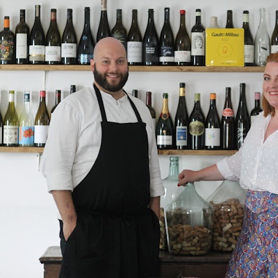 Daniel und Stephanie Lengsfeld aus dem Gasthaus Scheiderhöhe vor einer wand mit erlesenen Weinen.