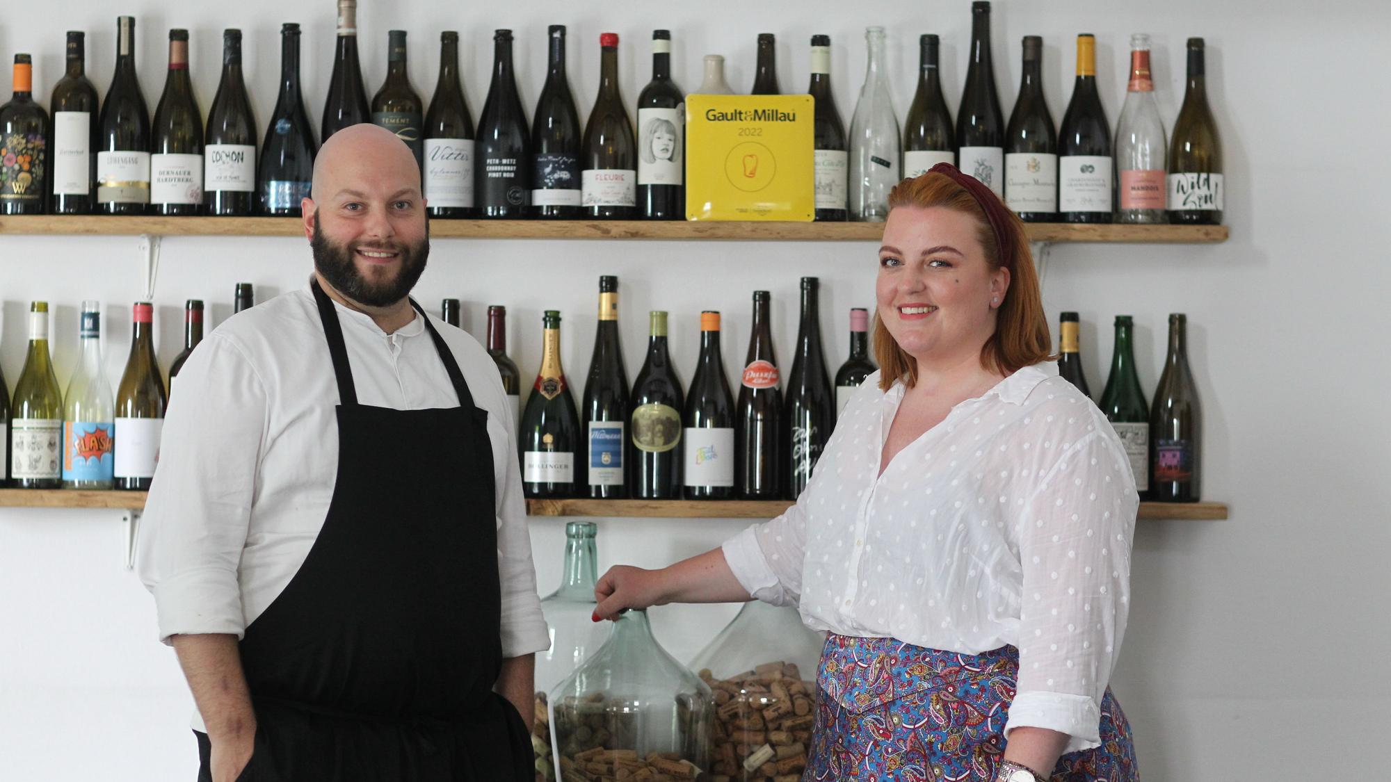 Daniel und Stephanie Lengsfeld stehen vor einem Weinregal in ihrem Gasthaus.