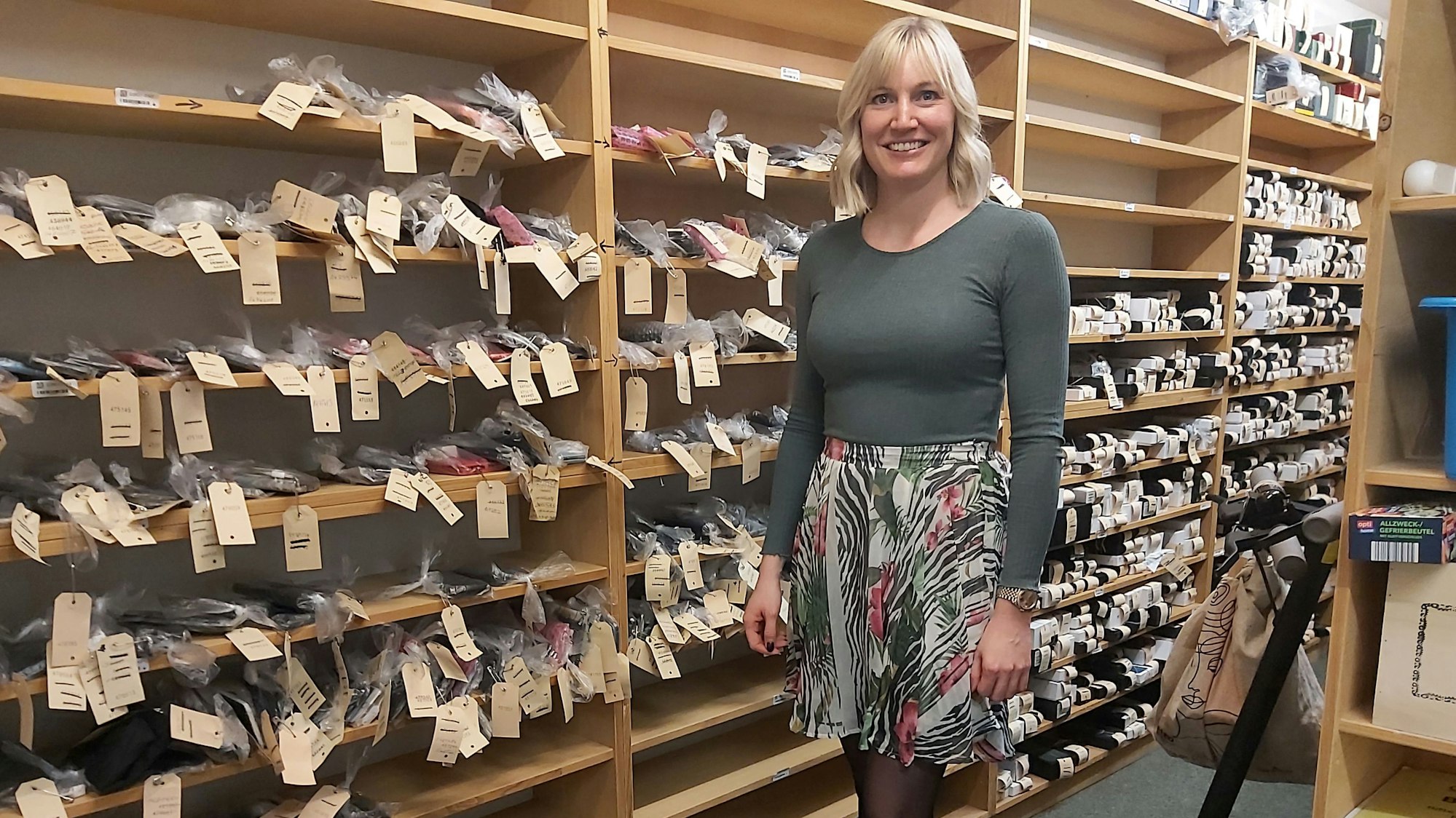 Maike Grüne, Geschäftsführerin „Grüne's Leihhaus“ vor dem Regal mit gepfändeten Handys in der Filiale in der Schildgergasse.