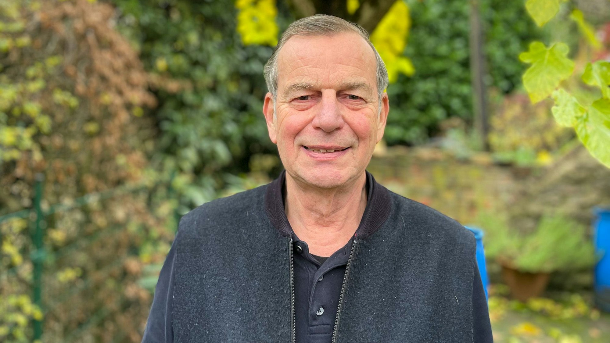 Porträt von Friedhelm Sarling vor einem Baum in seinem Garten.