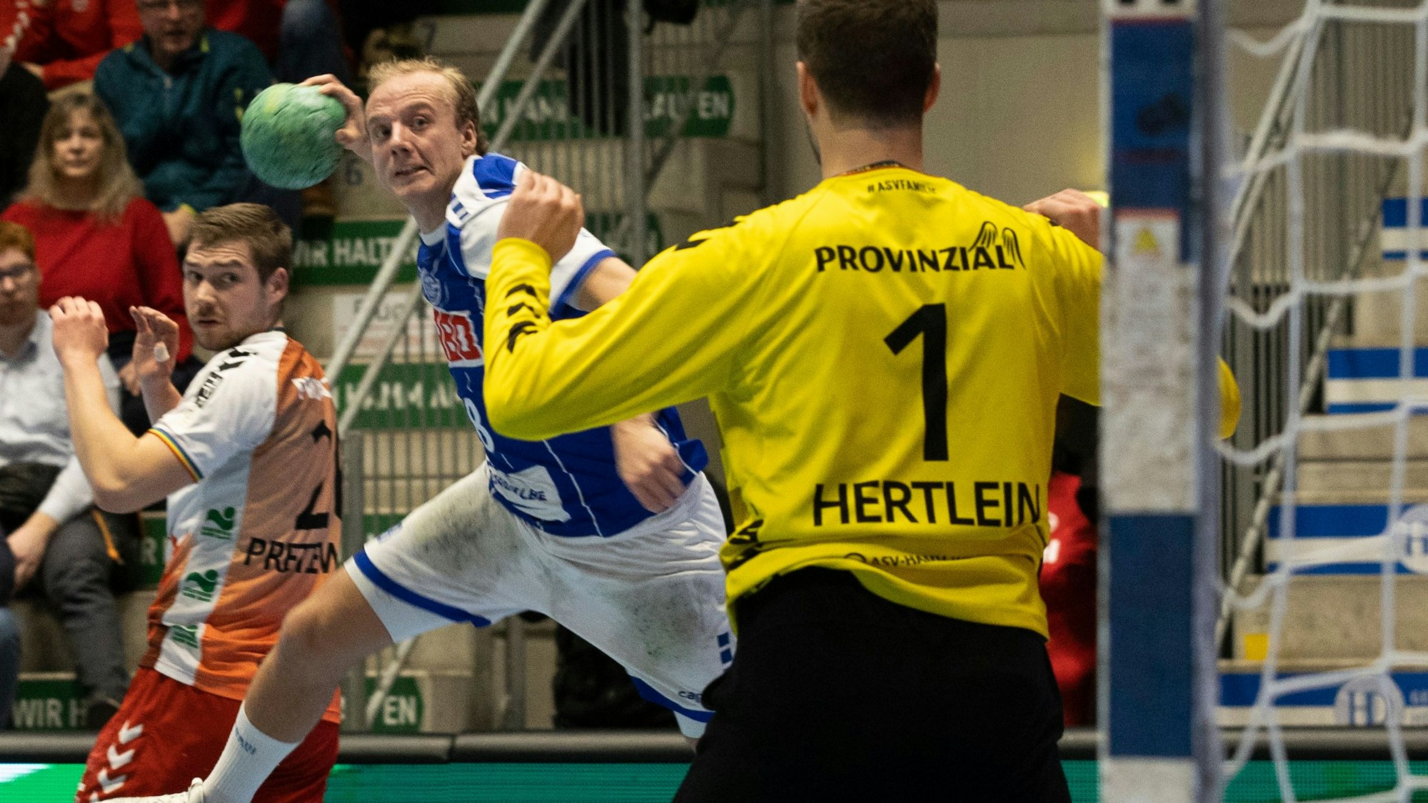 Zu sehen ist der Wurf eines Handballers auf ein Tor mit Torwart.