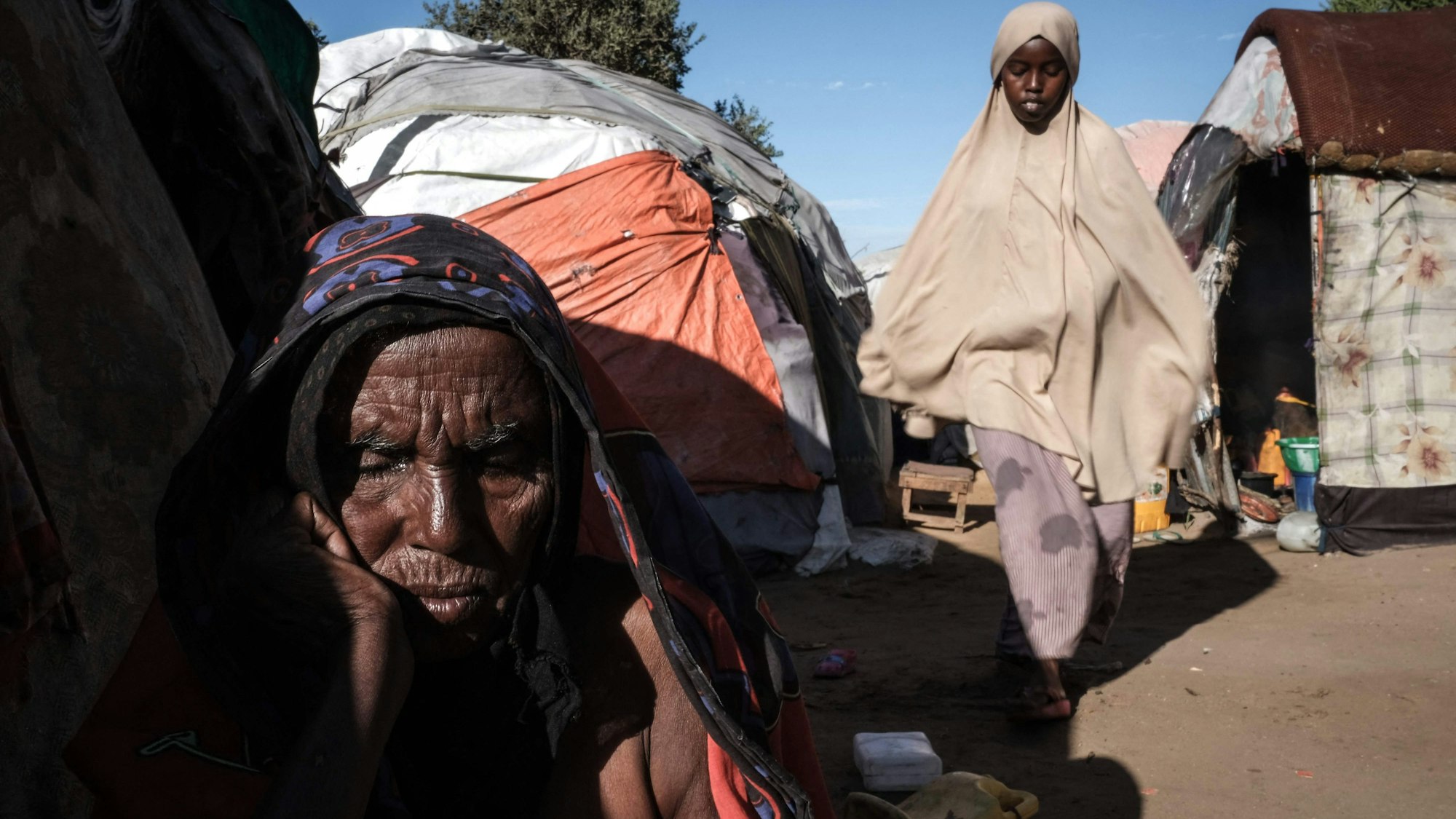 Ein Mann sitzt im Lager Limaan in Mogadischu, Somalia, vor einem behelfsmäßigen Zelt.