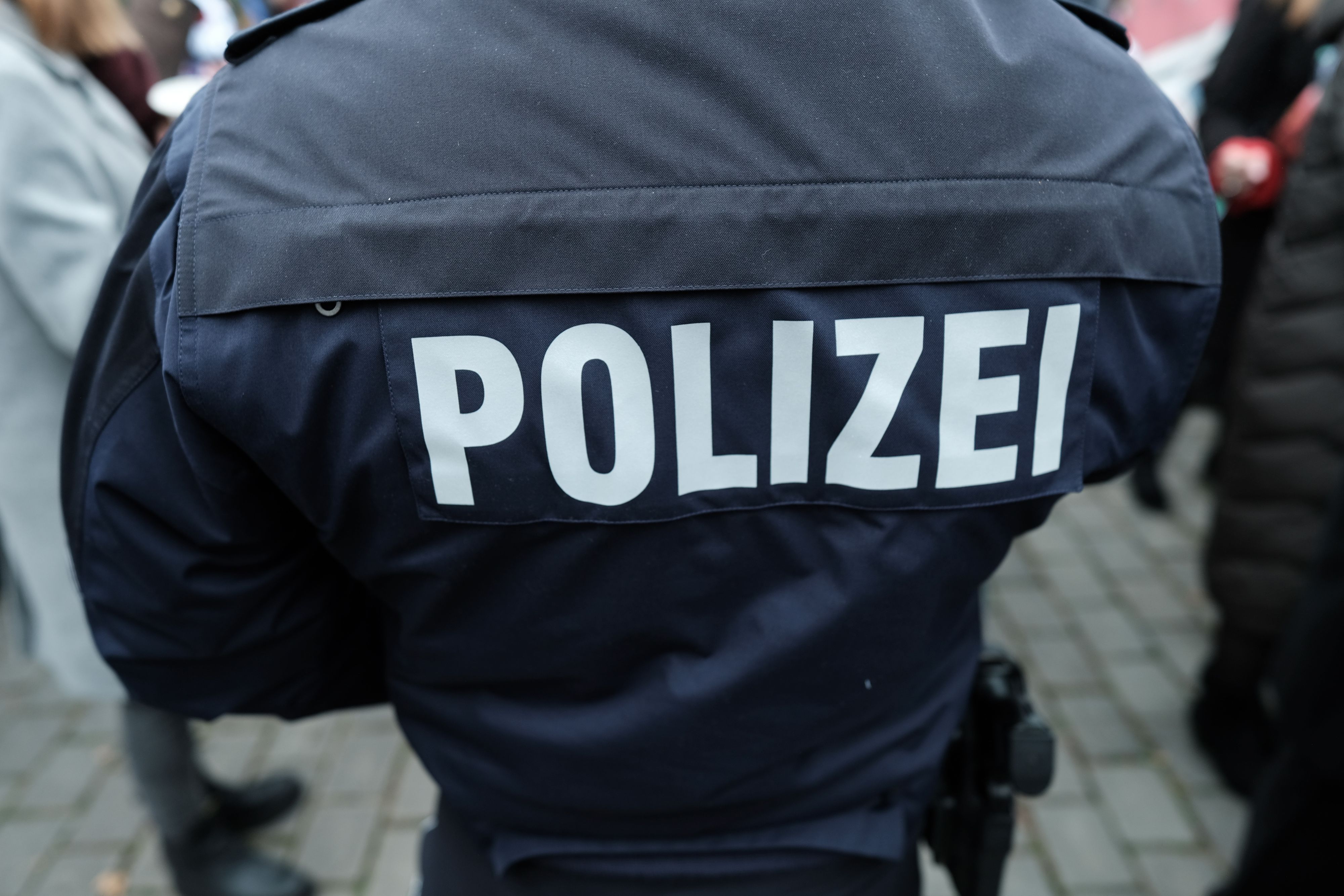 Auf einer blauen Jacke steht am Rücken der Schriftzug Polizei (Symbolbild)