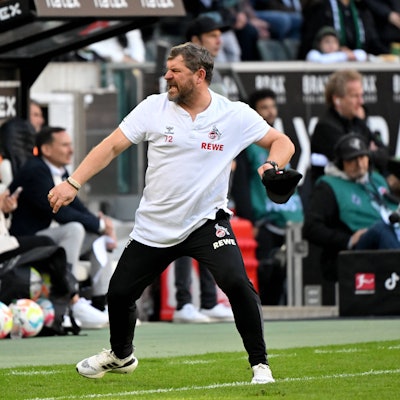 FC-Trainer Steffen Baumgart zieht sich jubelnd seine Mütze vom Kopf.