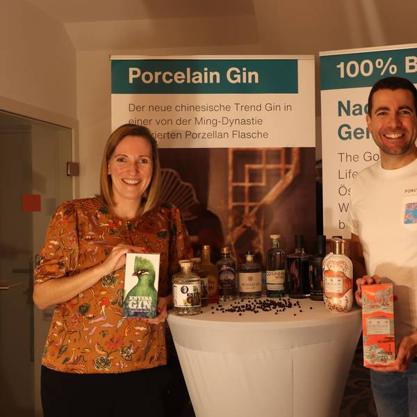 Christian Rüdiger und Claudia Olschewski von GlocalGin zeigen Pappbehälter mit ihren Produkten an einem Stehtisch