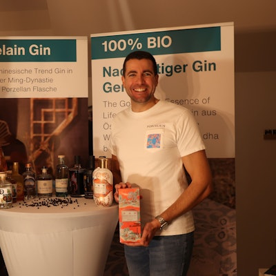 Christian Rüdiger und Claudia Olschewski von GlocalGin zeigen Pappbehälter mit ihren Produkten an einem Stehtisch